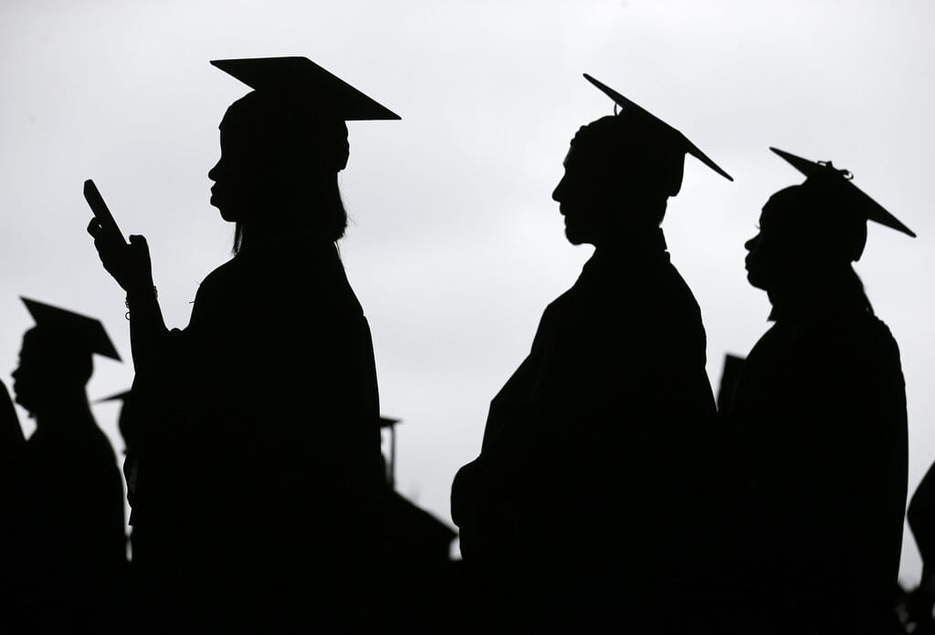 FILE - In this May 17, 2018, file photo, new graduates line up before the start of the Bergen Community College commencement at MetLife Stadium in East Rutherford, N.J.  There’s no single policy or action that will alleviate America’s $1.74 trillion student loan debt crisis while simultaneously preventing students from taking on unaffordable amounts of future debt. Higher education financing experts are divided on the exact combination of solutions, but all agree it will require a multipronged approach.  (AP Photo/Seth Wenig, File)